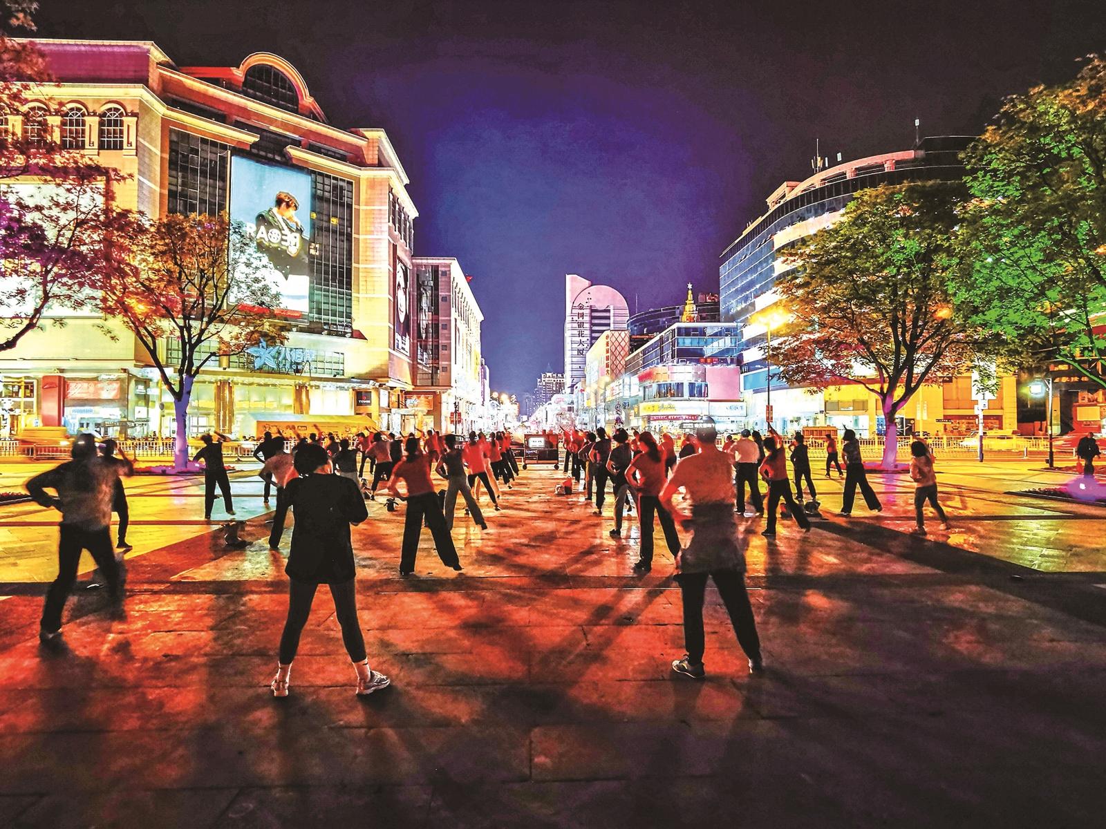 夏夜，市区钟楼广场，人们跳起广场舞。 钱肇宪
